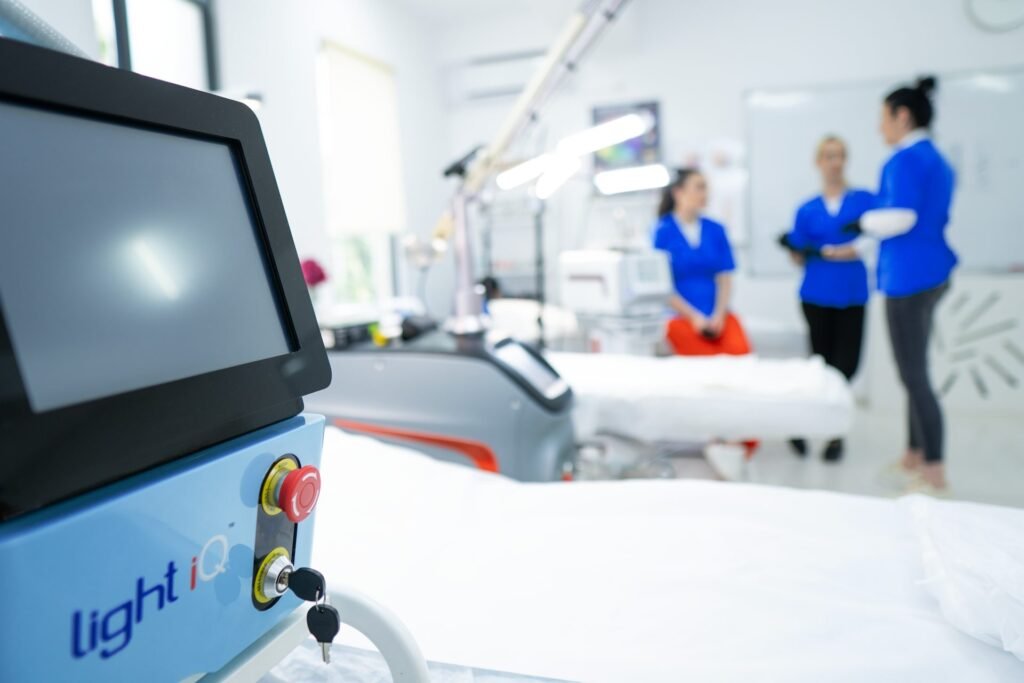 Aparat profesional în prim-plan într-o sală de practică a Colegiului de Estetică